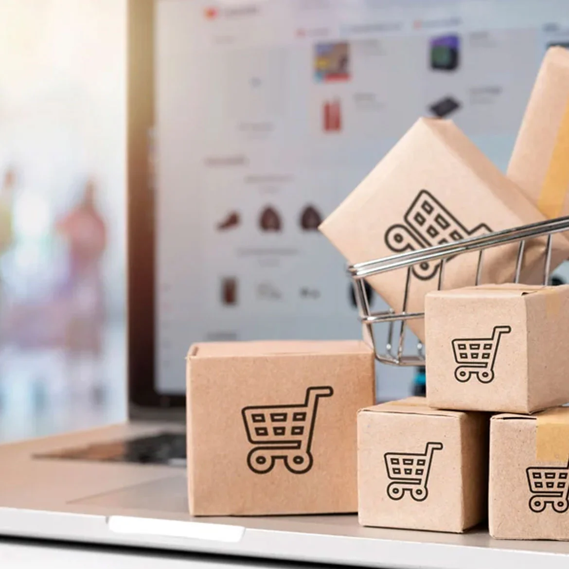 Pedidos de tienda online junto a un computador con un e-Commerce de fondo